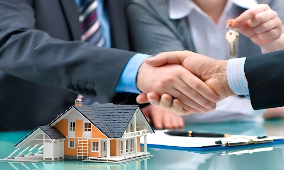 Real estate agent shaking hands with a client in front of a property