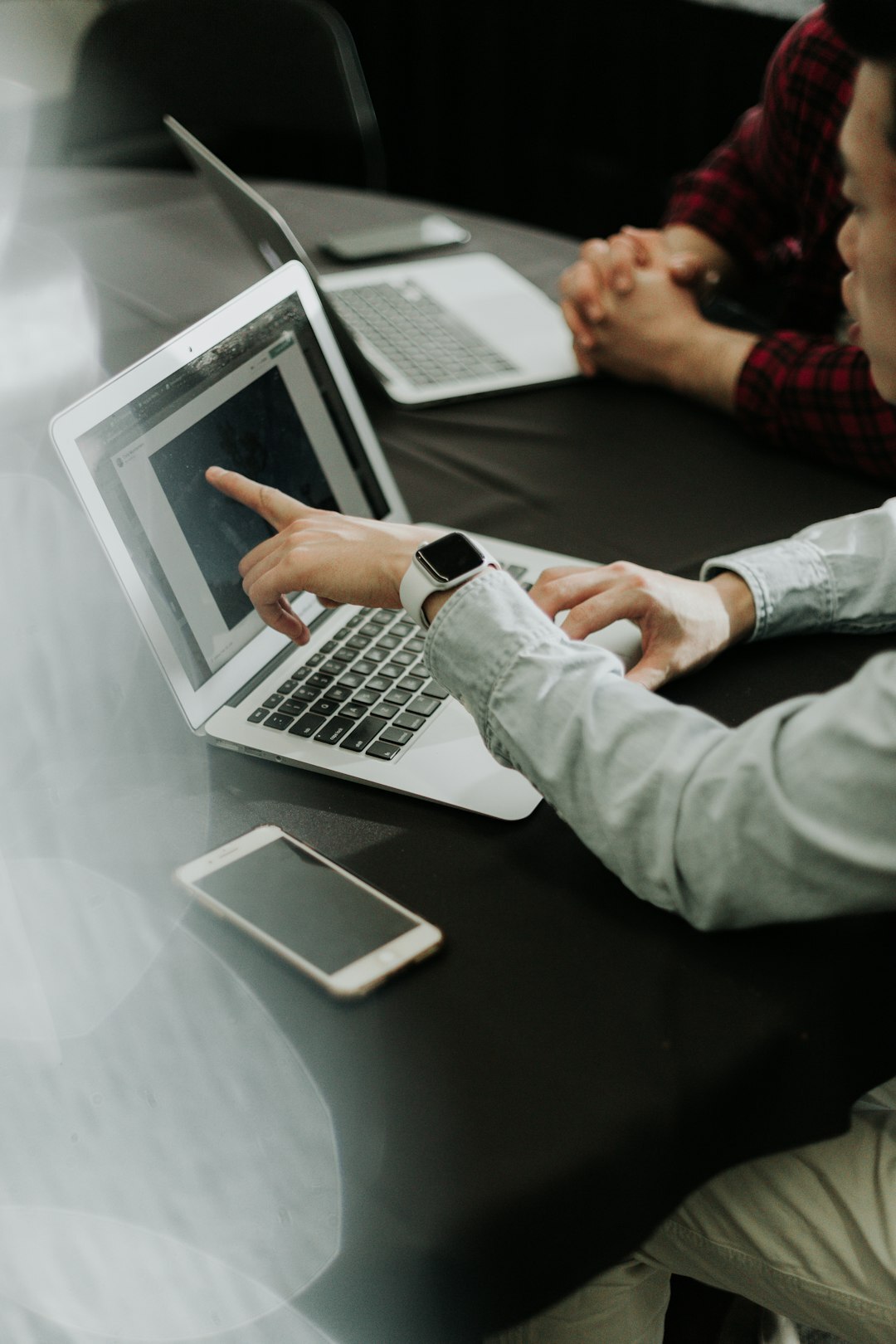 Technology professionals collaborating around a laptop